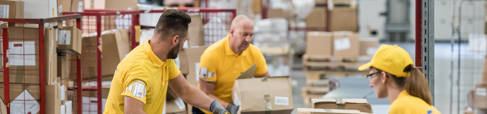 two men and a woman in a packaging operation